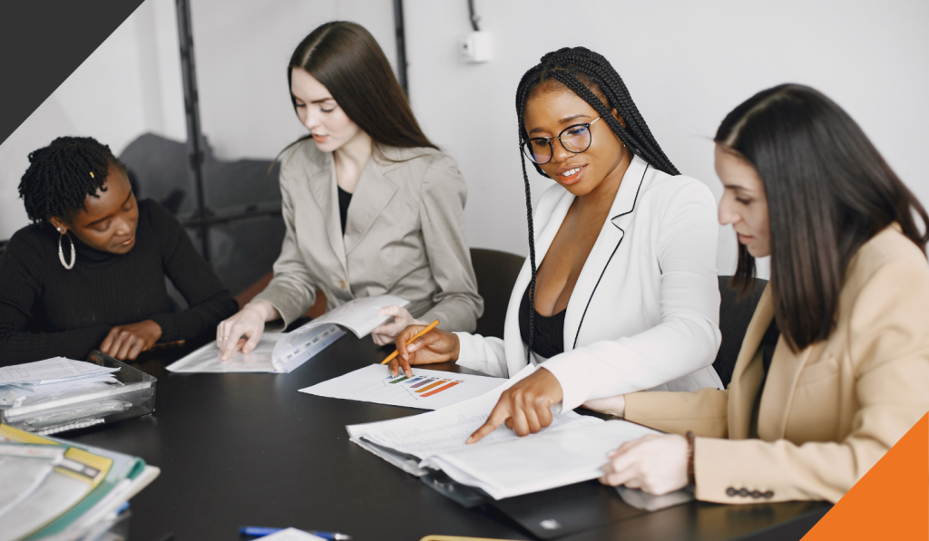 4 employees in seated around a meeting table discussing the path to cultural transformation i